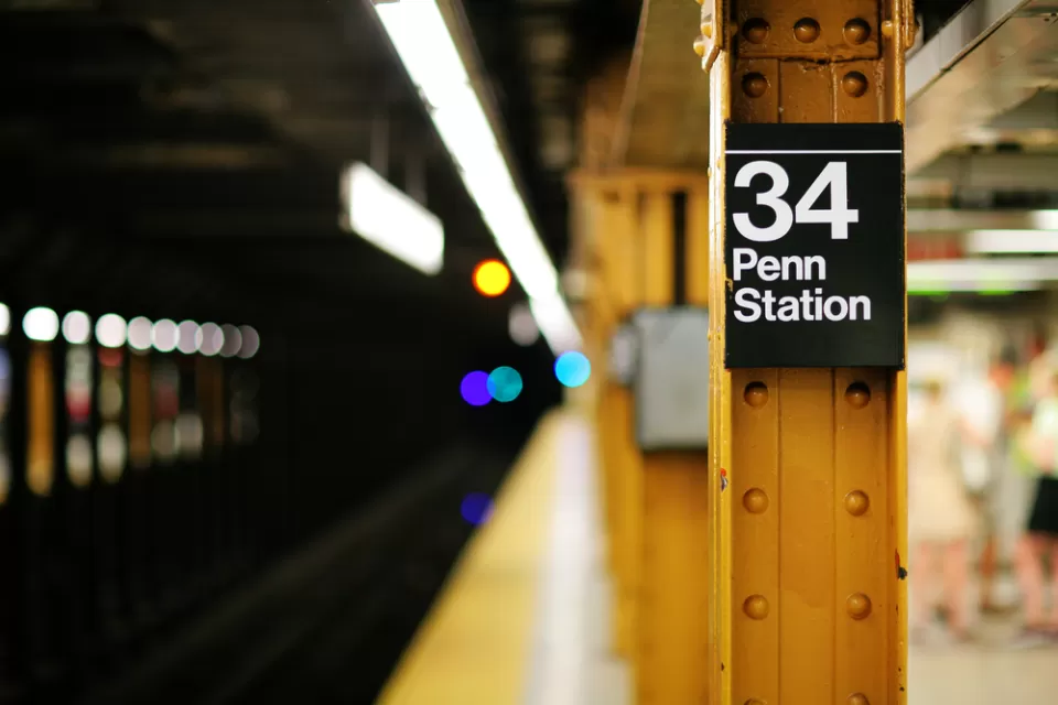 Close-up of yellow steel column on subway platform with sign: "34 Penn Station"